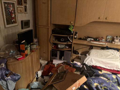 Unordentlicher Raum mit verstreuten Gegenständen, Wäsche und einem Schreibtisch.