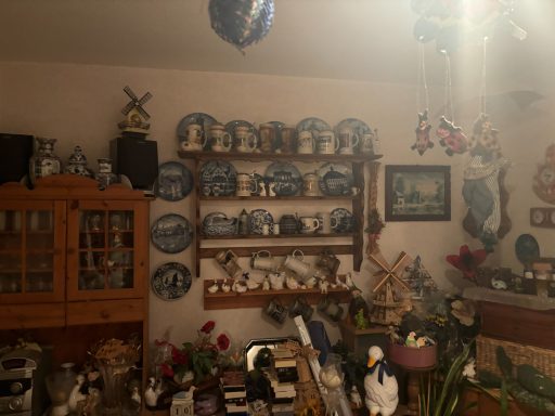 Ein gemütlicher Raum mit Regalen voller blauer Teller und dekorativen Gegenständen.